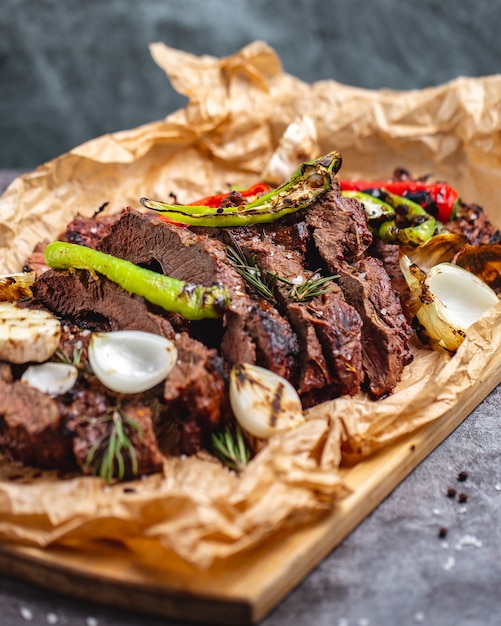 Bistecca cotta media con aglio cipolla rossa e peperoncino su carta pergamena