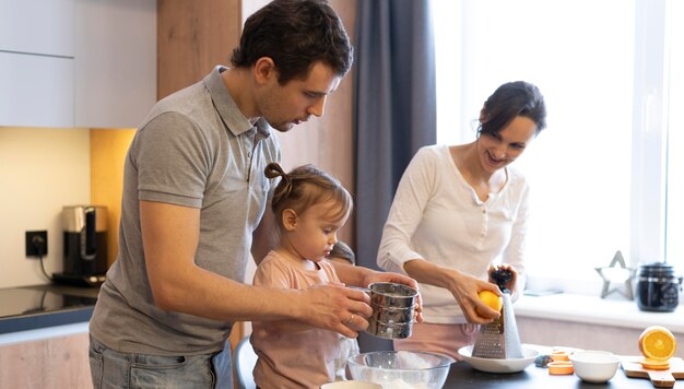 Medium shot adults and kid in kitchen