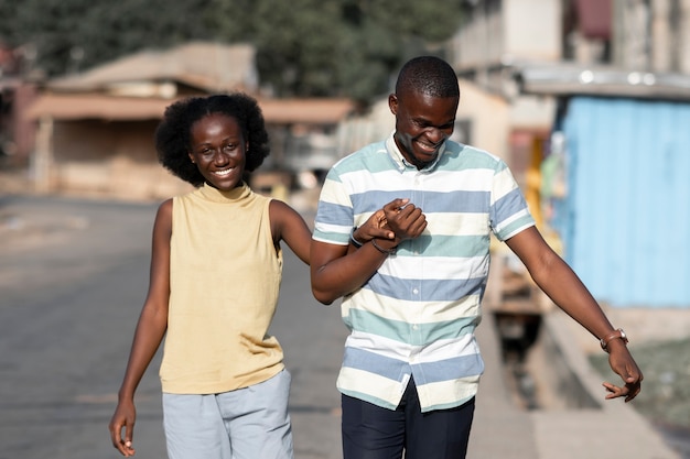 Бесплатное фото Средний снимок африканской пары, взявшись за руки