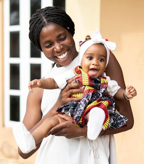 Medium shot african mother holding little girl
