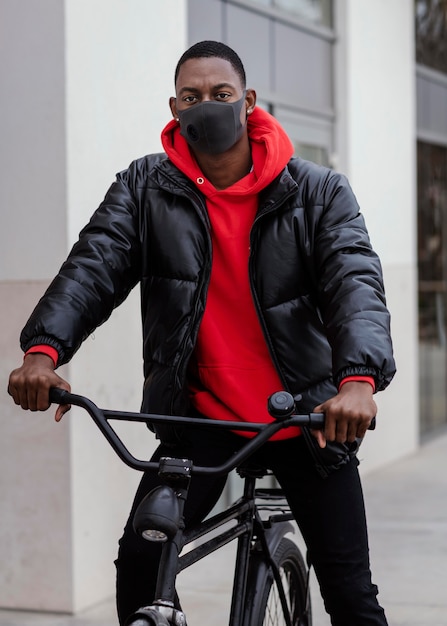 ミディアムショットのアフリカ系アメリカ人男性と彼の自転車