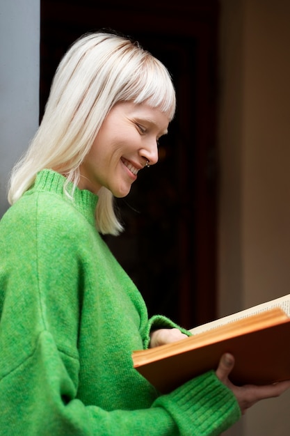 Женщина-альбинос среднего роста читает