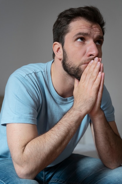 祈るミディアムショットの気になる男