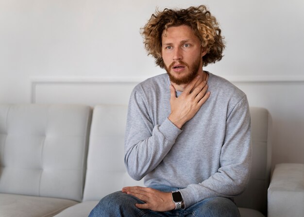 Medium shot anxious man sitting on couch