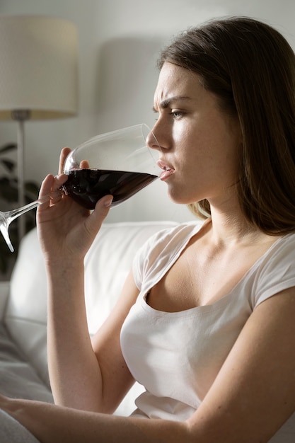 와인을 마시는 미디엄 샷 불안한 여성