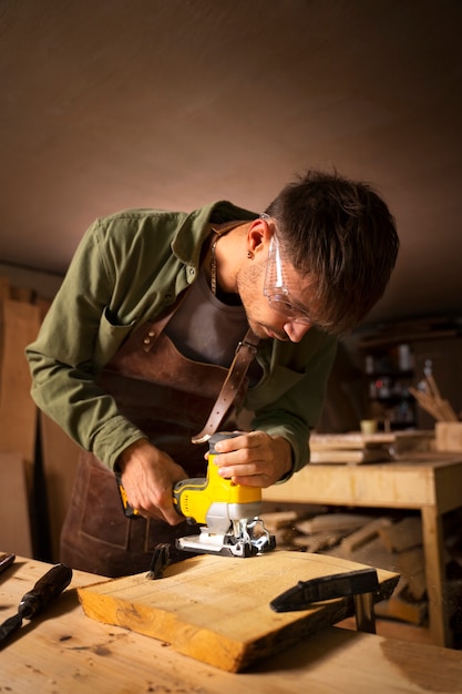 Foto gratuita artigiano di tiro medio che fa il taglio del legno