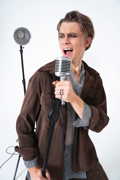 Free photo medium shot artist singing with microphone