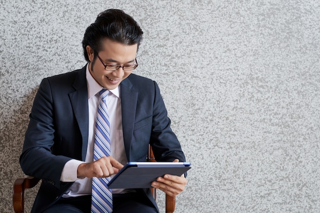 Free photo medium shot of asian business man using the digital pad