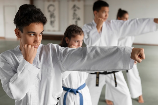 Foto gratuita medium shot asiatici che praticano taekwondo