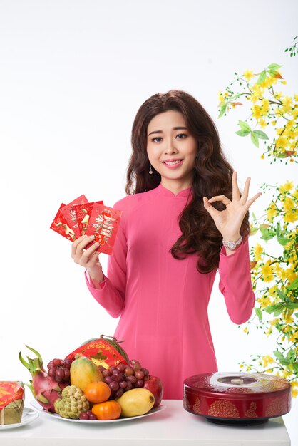 Medium shot of Asian woman congratulating on spring festival with a gesture