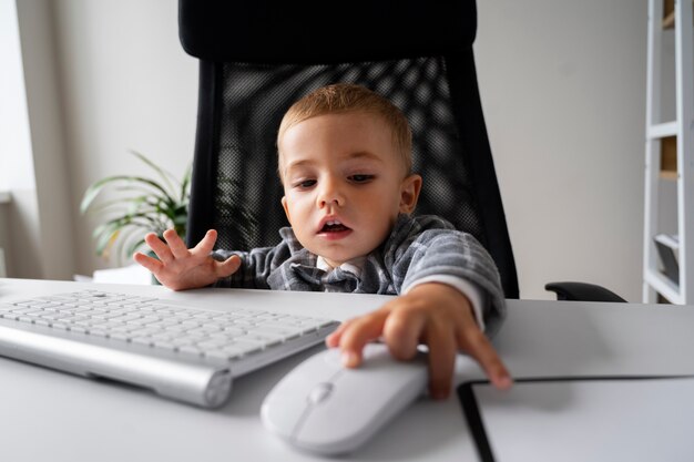 Medium shot baby at desk with mouse