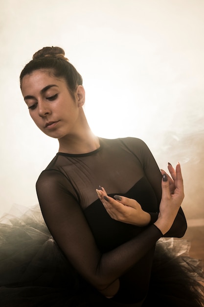 Free photo medium shot ballerina posing in smoke