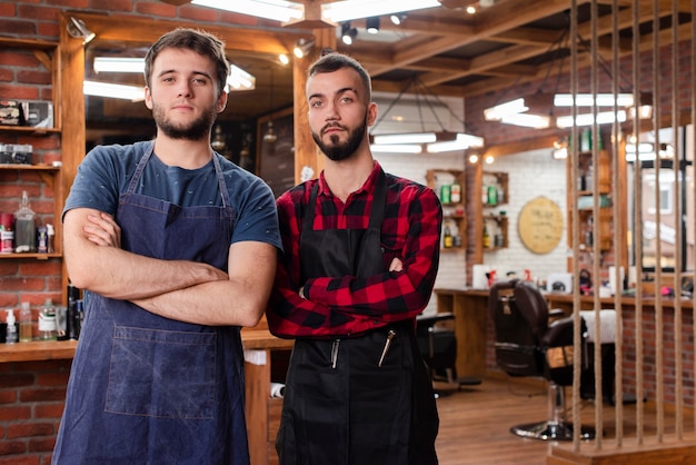 Medium shot barbers standing with crossed arms
