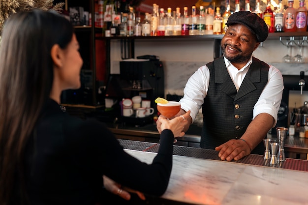 Medium shot bartender preparing drink  for customer