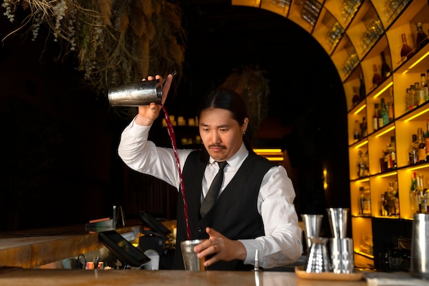 Free photo medium shot bartender preparing drink