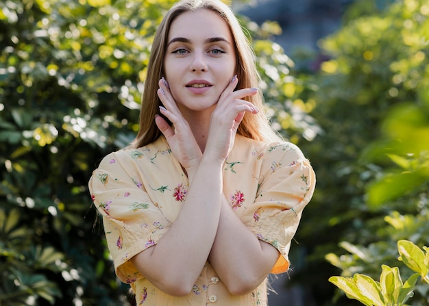 Medium shot of beautiful woman holding her hands on her face