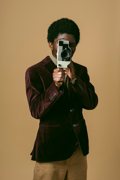 오래된 카메라로 녹음하는 중간 샷 흑인 남자