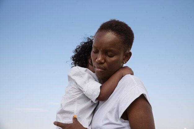 Medium shot black woman holding kid