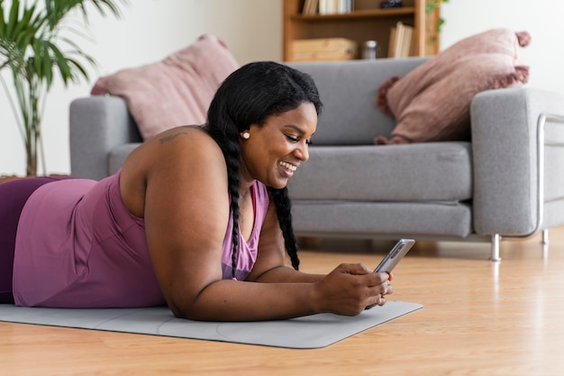 Medium shot black woman relaxing at home