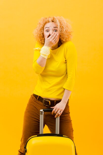 Medium shot of blonde woman with suitcase