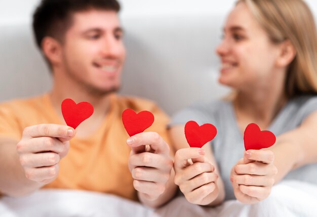 Medium shot blurred couple holding heart shaped paper