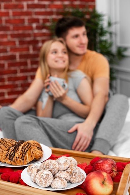 Free photo medium shot blurred couple with breakfast in bed