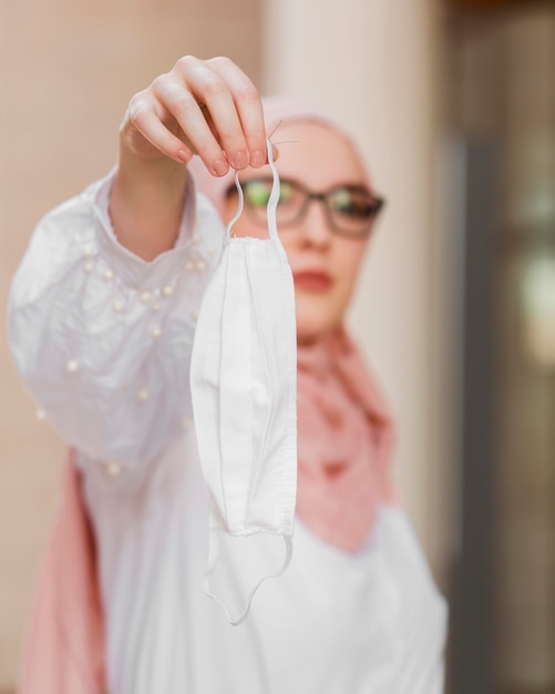 Medium shot blurred woman holding mask