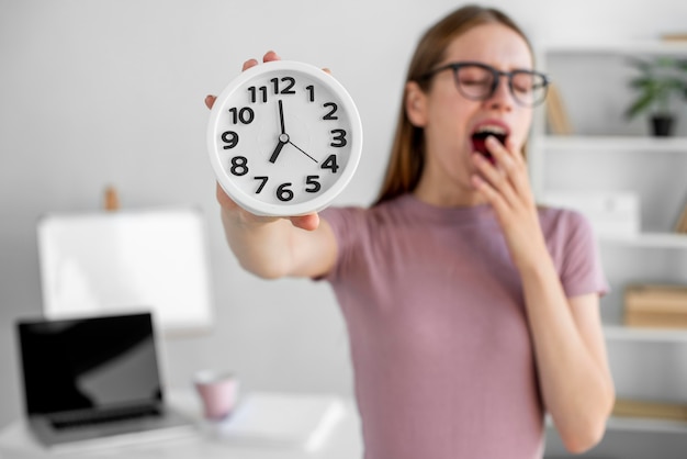 Medium shot blurry woman holding clock