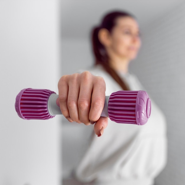 Free photo medium shot blurry woman holding dumbbell