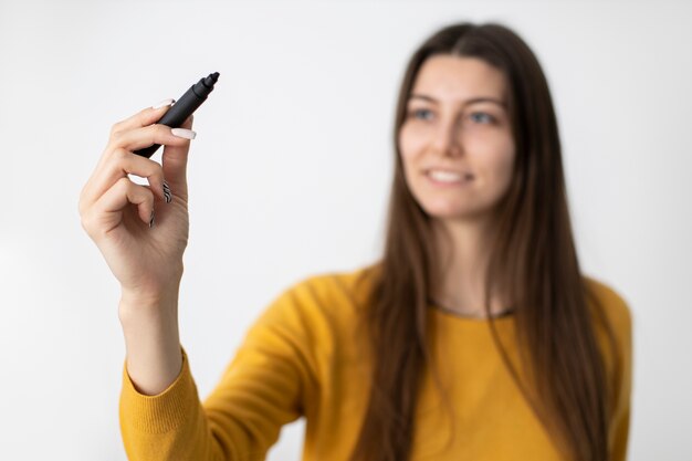 マーカーを保持しているミディアムショットぼやけた女性