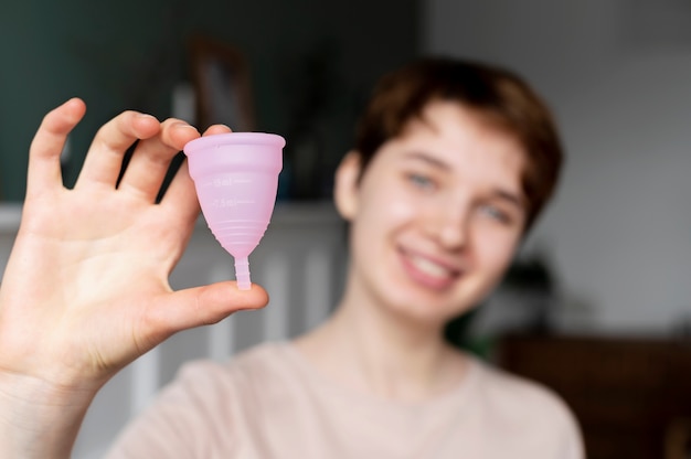 Free photo medium shot blurry woman holding menstrual cup