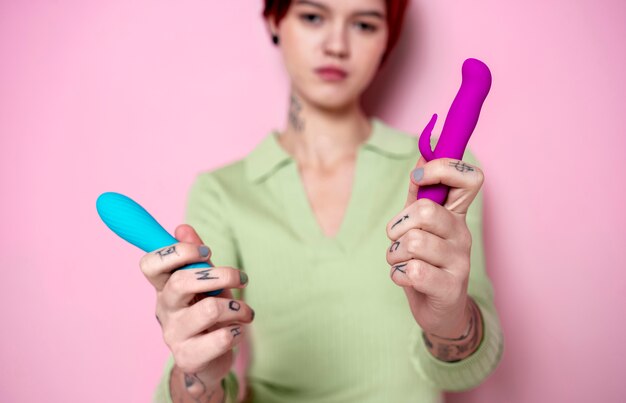 Medium shot blurry woman holding vibrators