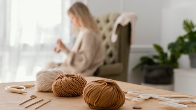 Free photo medium shot blurry woman knitting indoors