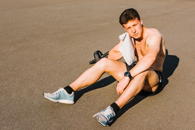 Medium shot of body builder taking a break