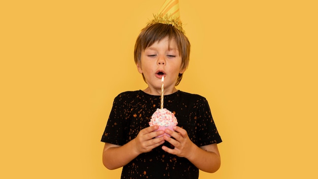 Free photo medium shot boy blowing candle