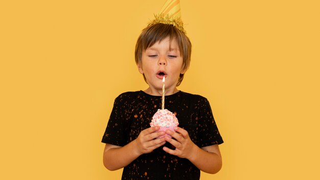 Medium shot boy blowing candle