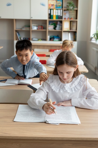 学校で女の子を悩ませているミディアムショットの男の子