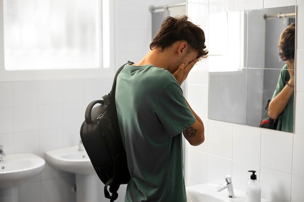 Free photo medium shot boy crying in bathroom