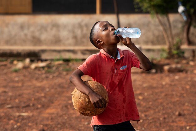 Medium shot boy drinking water