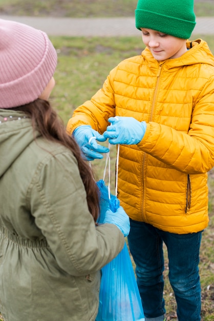 Free photo medium shot of boy helping little girl