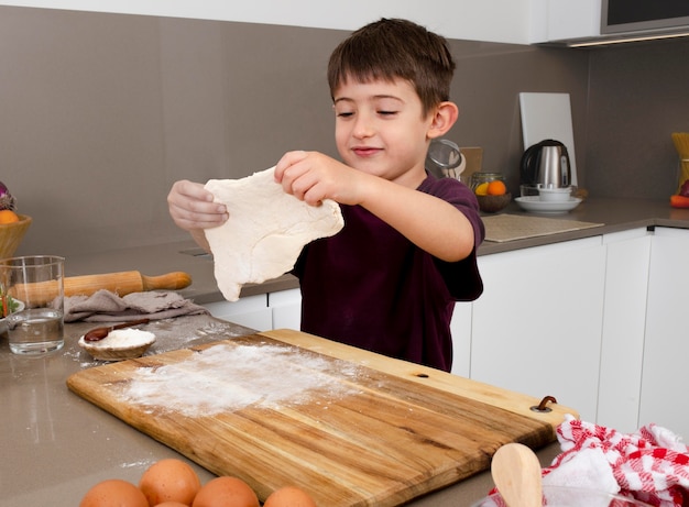 無料写真 ミディアムショットの男の子が生地を詰める