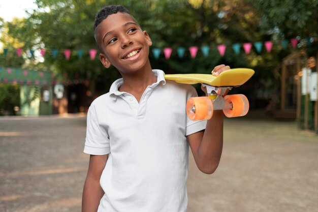 Medium shot boy holding penny board