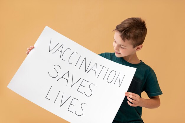 Free photo medium shot boy holding placard with message