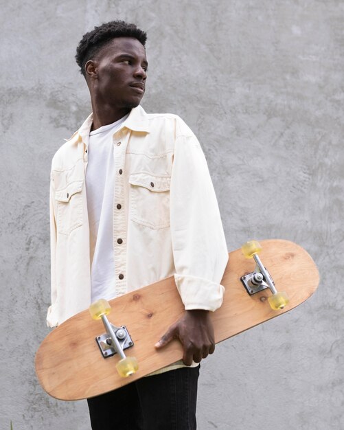 Medium shot boy holding skateboard