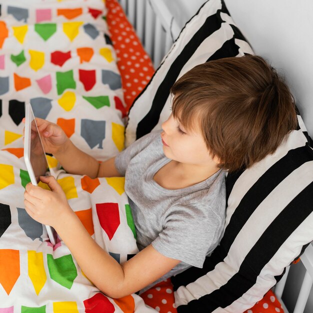 Medium shot boy holding tablet