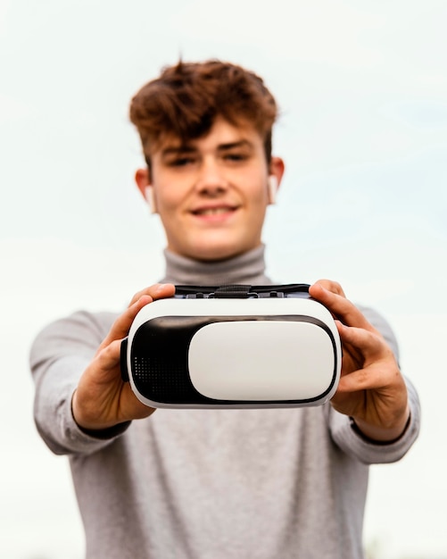 Medium shot boy holding virtual reality glasses