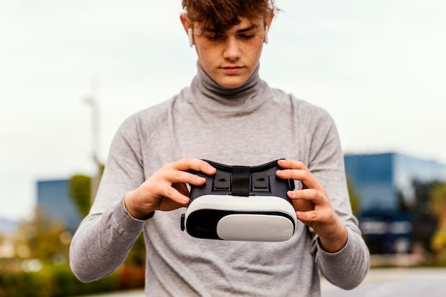 Medium shot boy holding vr glasses