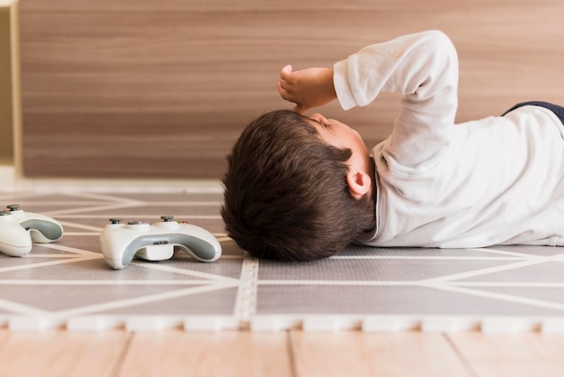 Free photo medium shot boy laying on floor