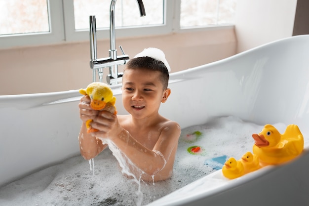 Foto gratuita ragazzo del tiro medio che gioca nella vasca da bagno