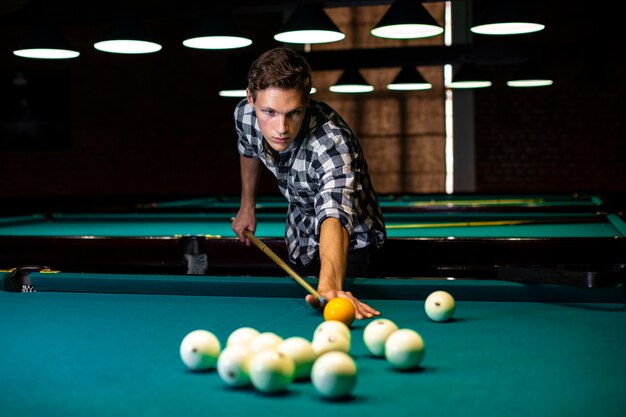 Medium shot boy playing billiard